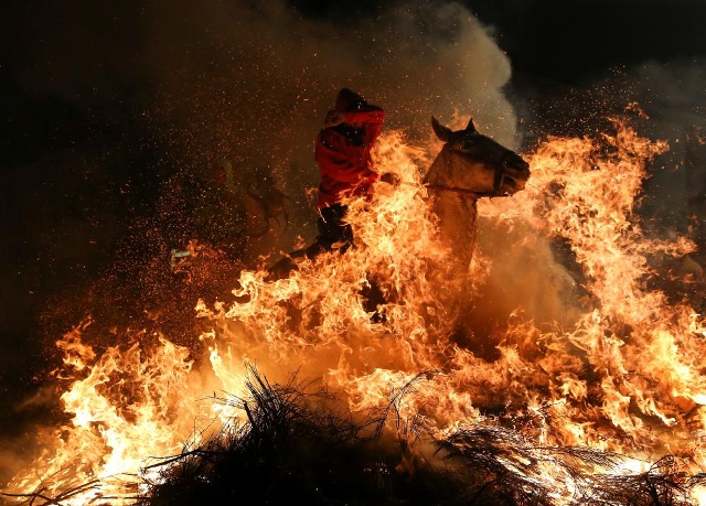 Một người đàn ông cưỡi một con ngựa qua ngọn lửa trong 