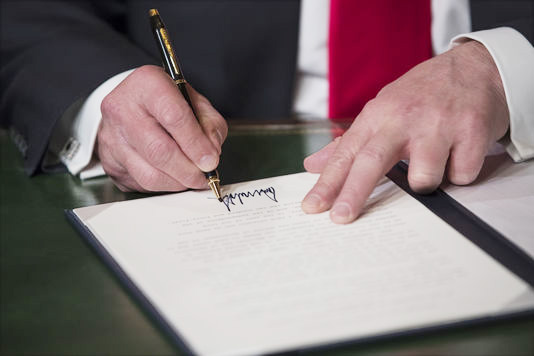 Ông Donald Trump ký vào quyết định bổ nhiệm chính mình ở Capitol, Washington ngày 20/1/2017. 	Ảnh: AFP