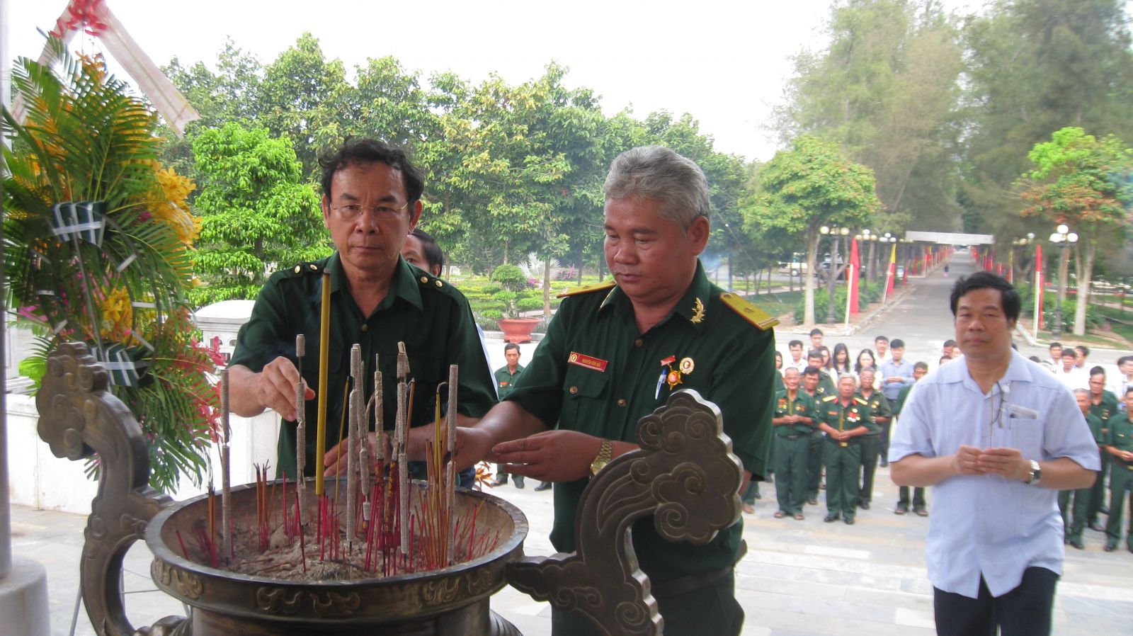 Ông Nguyễn Văn Nên (bên trái) thắp hương tại đài tưởng niệm các anh hùng liệt sĩ.