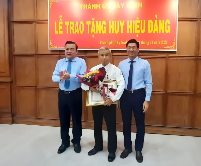 Đồng chí Phạm Hùng Thái (bìa trái)- Phó Bí thư Thường trực Tỉnh ủy Tây Ninh, đồng chí Nguyễn Mạnh Hùng (bìa phải)-Phó bí thư Tỉnh ủy trao huy hiệu và tặng hoa chúc mừng đảng viên