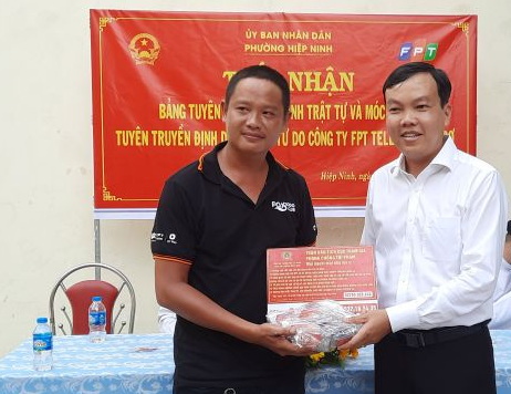 Đại diện Công ty cổ phần Viễn thông FPT Chi nhánh Tây Ninh trao bảng tuyên truyền cho lãnh đạo phường Hiệp Ninh