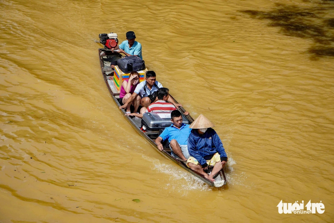 Người dân ở TP Huế, Thừa Thiên Huế dùng ghe để di chuyển, đưa người và các vật dụng qua dòng nước lũ trong đợt mưa lũ giữa tháng 11-2023 - Ảnh: LÊ TRUNG