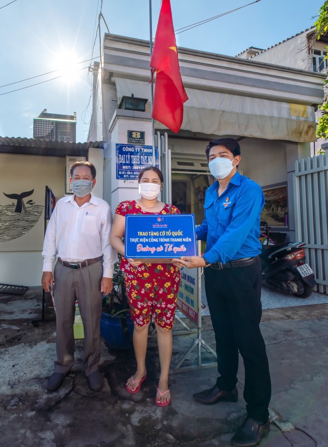 Bí thư Thành đoàn Tây Ninh và Trưởng Ban quản lý khu phố 2, phường 3 trao tặng cờ Tổ quốc cho người dân.
