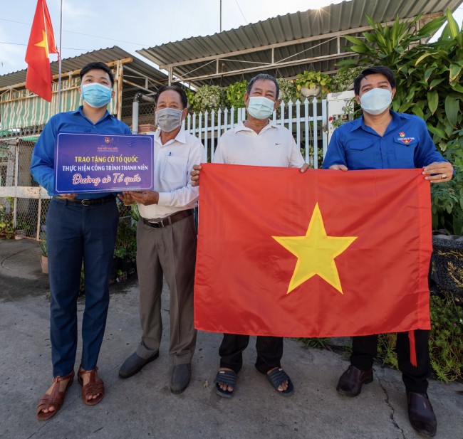 Bí thư Thành đoàn Tây Ninh và Trưởng Ban quản lý khu phố 2, phường 3 trao tặng cờ Tổ quốc cho người dân.