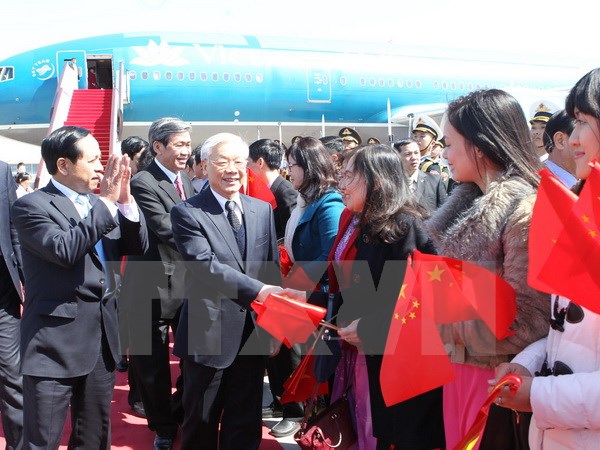 Cán bộ, nhân viên Đại sứ quán và đại diện cộng đồng, lưu học sinh Việt Nam đón Tổng Bí thư Nguyễn Phú Trọng cùng Đoàn đại biểu cấp cao Việt Nam tại sân bay quốc tế Bắc Kinh. (Ảnh: Trí Dũng/TTXVN)