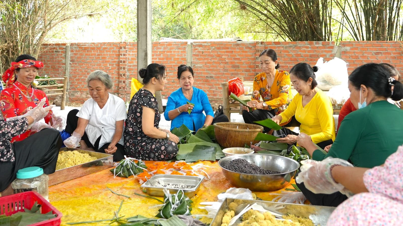 Mọi người cùng quây quần chung tay chuẩn bị những phần bánh truyền thống như bánh ít, bánh tét để tham gia phiên chợ.