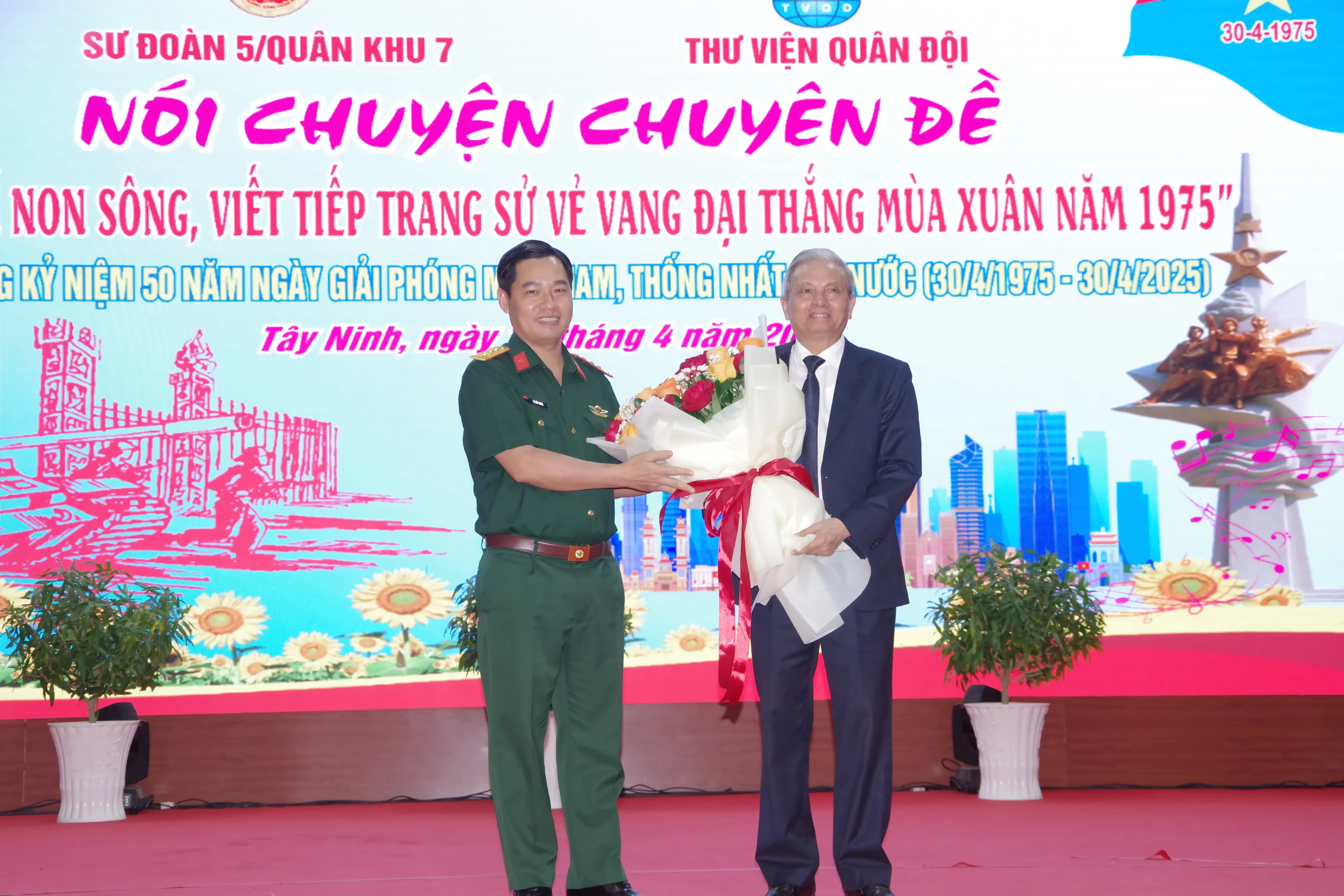 Thượng tá Lê Ðức Nhân, Phó Chính uỷ Sư đoàn 5 tặng hoa chúc mừng cựu chiến binh Lê Doãn Hợp, nhân dịp về nói chuyện chuyên đề “Hào khí non sông, viết tiếp trang sử vẻ vang Ðại thắng mùa Xuân năm 1975” tại Sư đoàn 5.