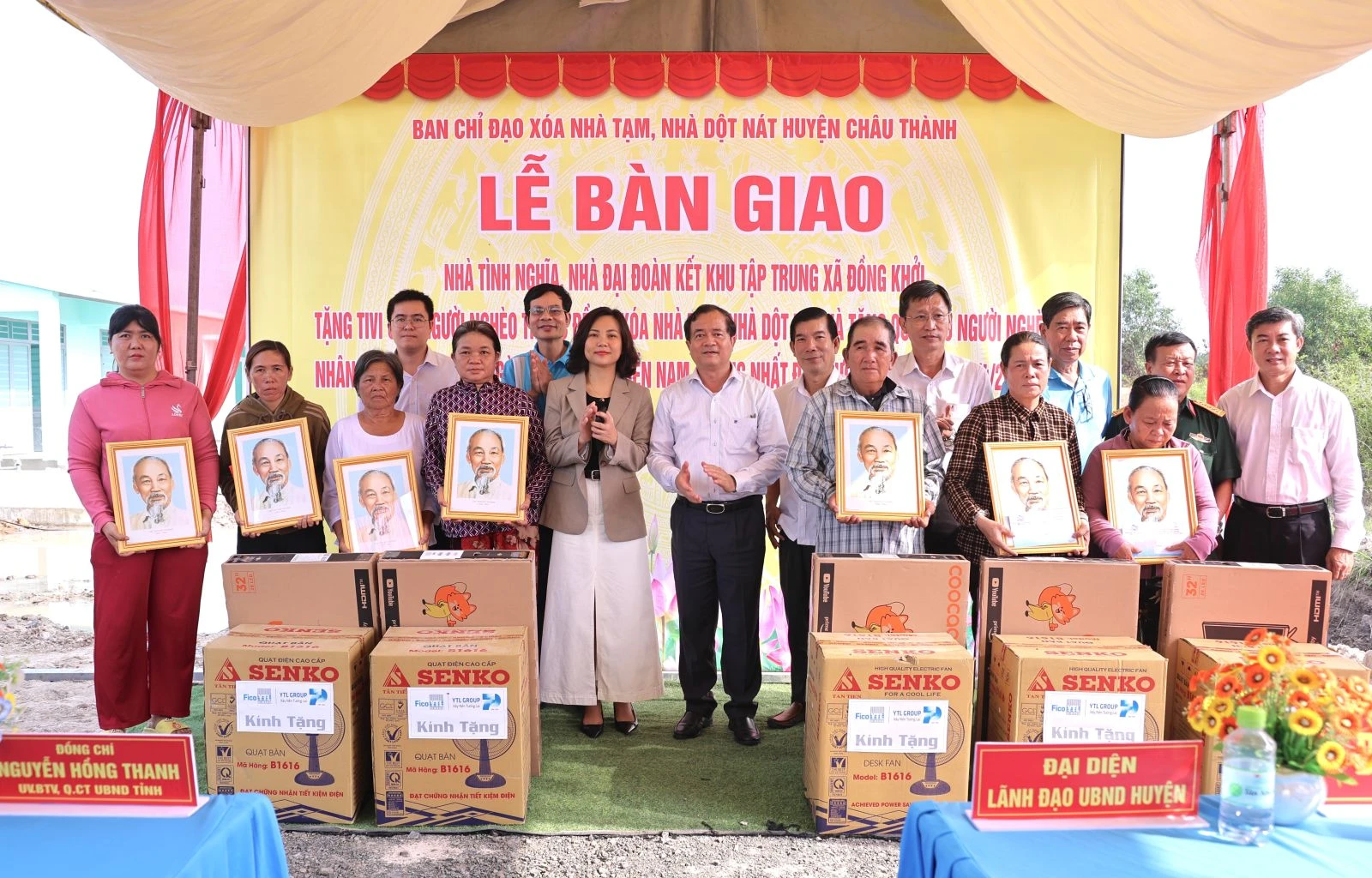Lãnh đạo tỉnh, huyện và các đơn vị đồng hành trao quyết định bàn giao nhà, tặng cờ Tổ quốc, ảnh Bác Hồ và tivi cho các hộ được nhận nhà tại lễ bàn giao.