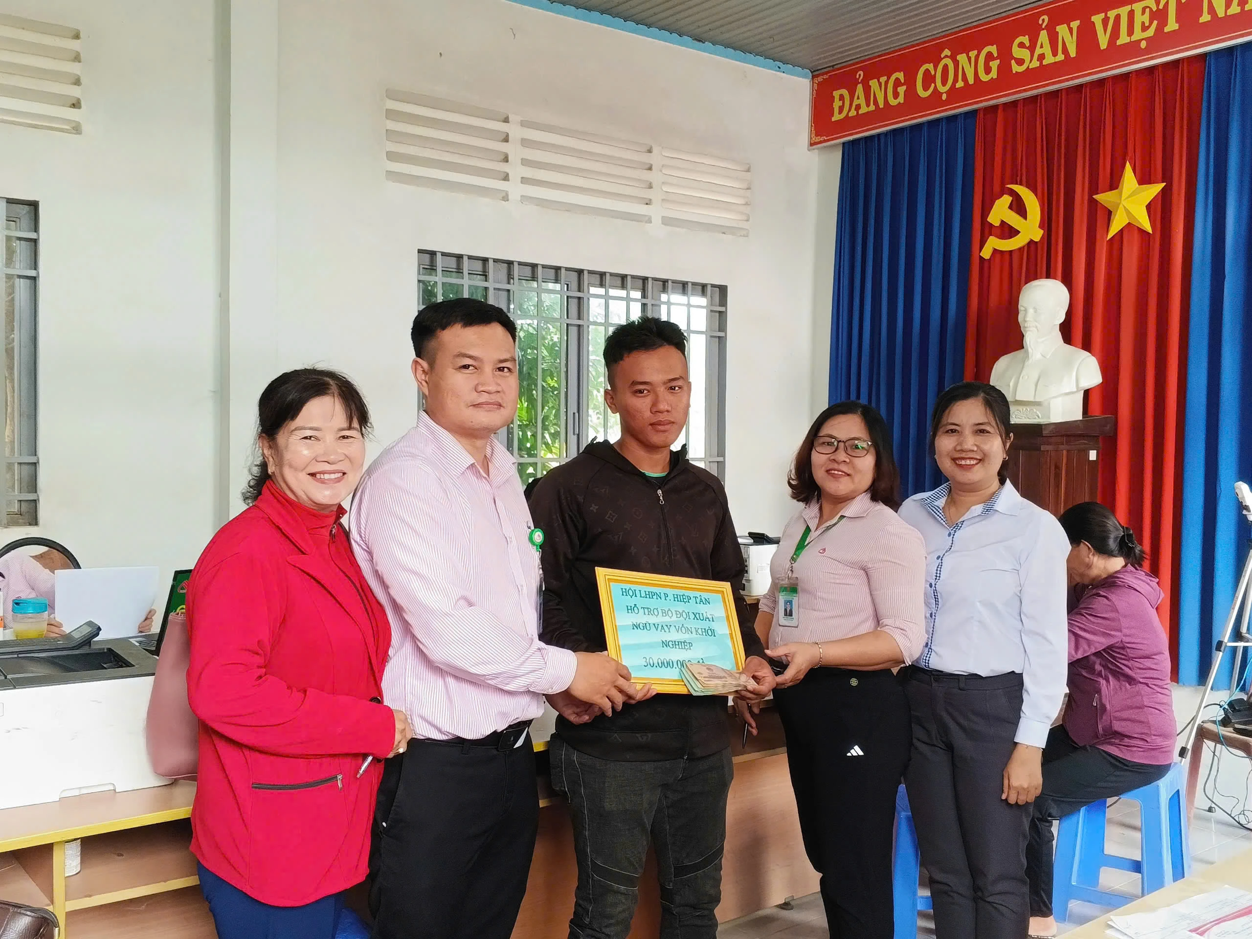 Cán bộ phòng giao dịch Ngân hàng Chính sách xã hội thị xã Hoà Thành và Chủ tịch Hội LHPN phường Hiệp Tân (bìa phải) trao vốn cho bộ đội xuất ngũ