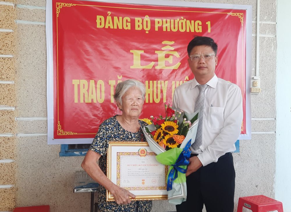 Ông Lê Minh Thế- Bí thư Thành ủy Tây Ninh trao huy hiệu cho đảng viên Chu Thị Cất