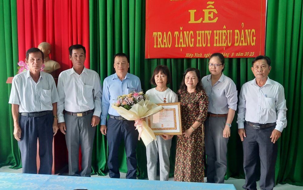 Bà Hồ Tuyết Huỳnh Mai-Ủy viên Ban Thường vụ Thành ủy-Phó Chủ tịch HĐND Thành phố trao huy hiệu cho đảng viên Trần Loan Anh