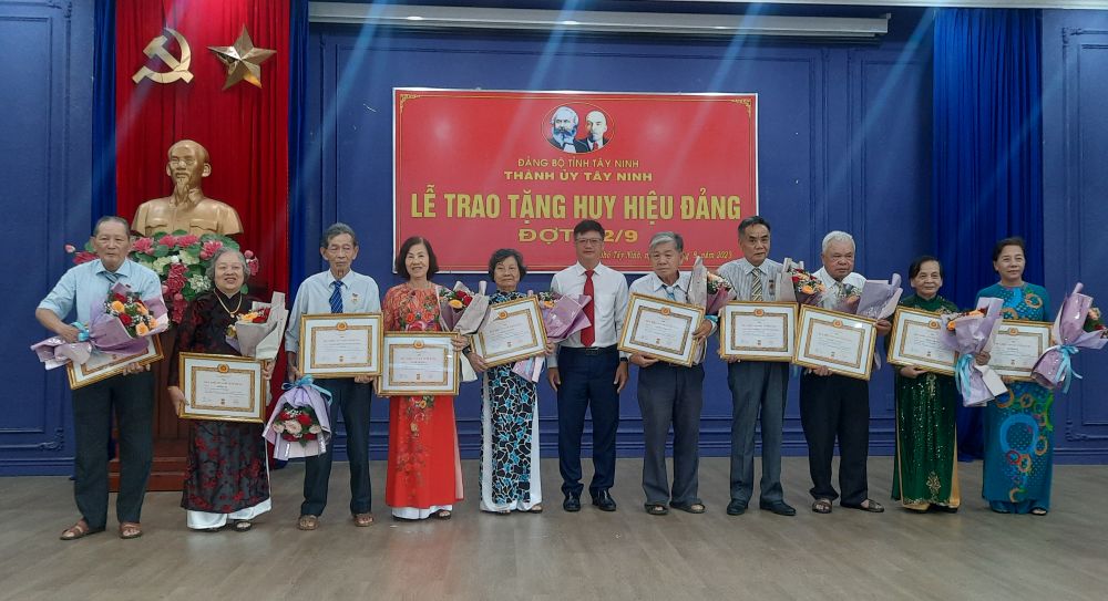 Ông Lê Minh Thế-Ủy viên Ban Thường vụ tỉnh ủy-Bí thư Thành ủy trao huy hiệu cho các đảng viên