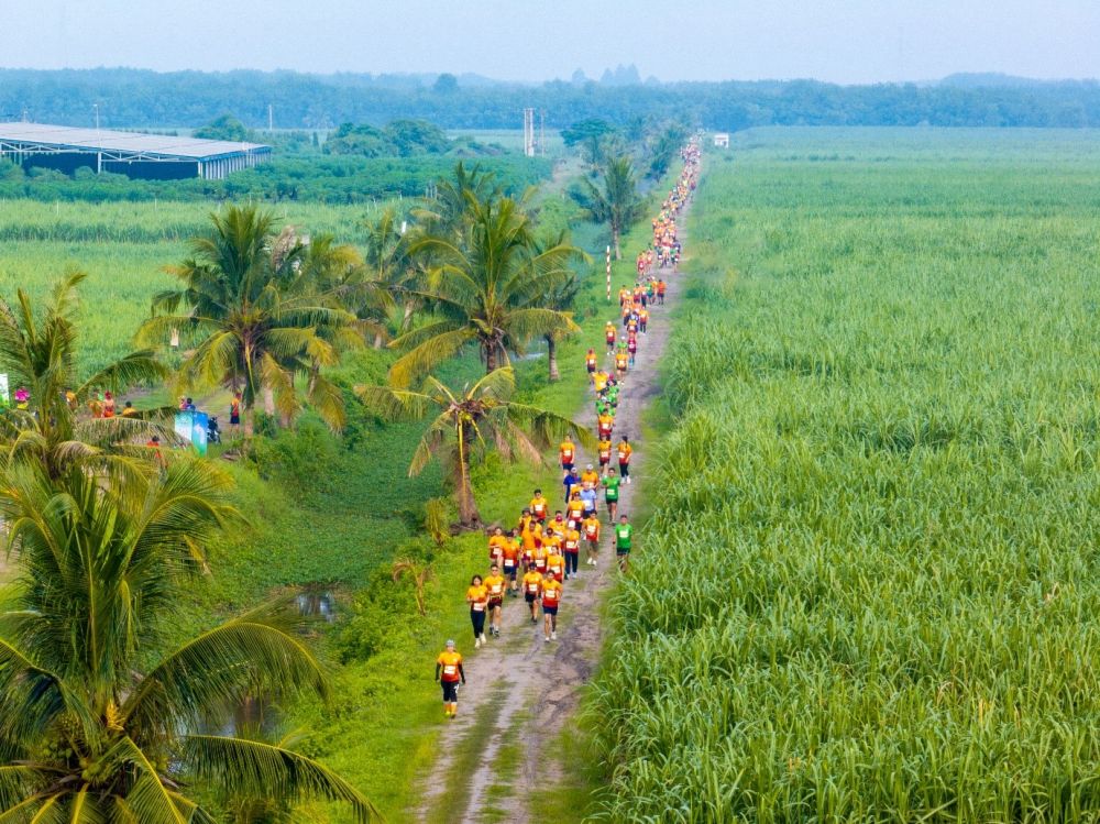 A group of people walking on a dirt roadDescription automatically generated