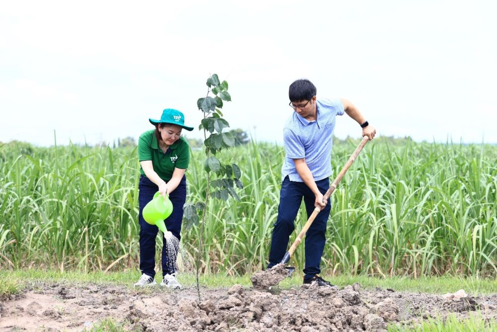 A person and person watering a treeDescription automatically generated