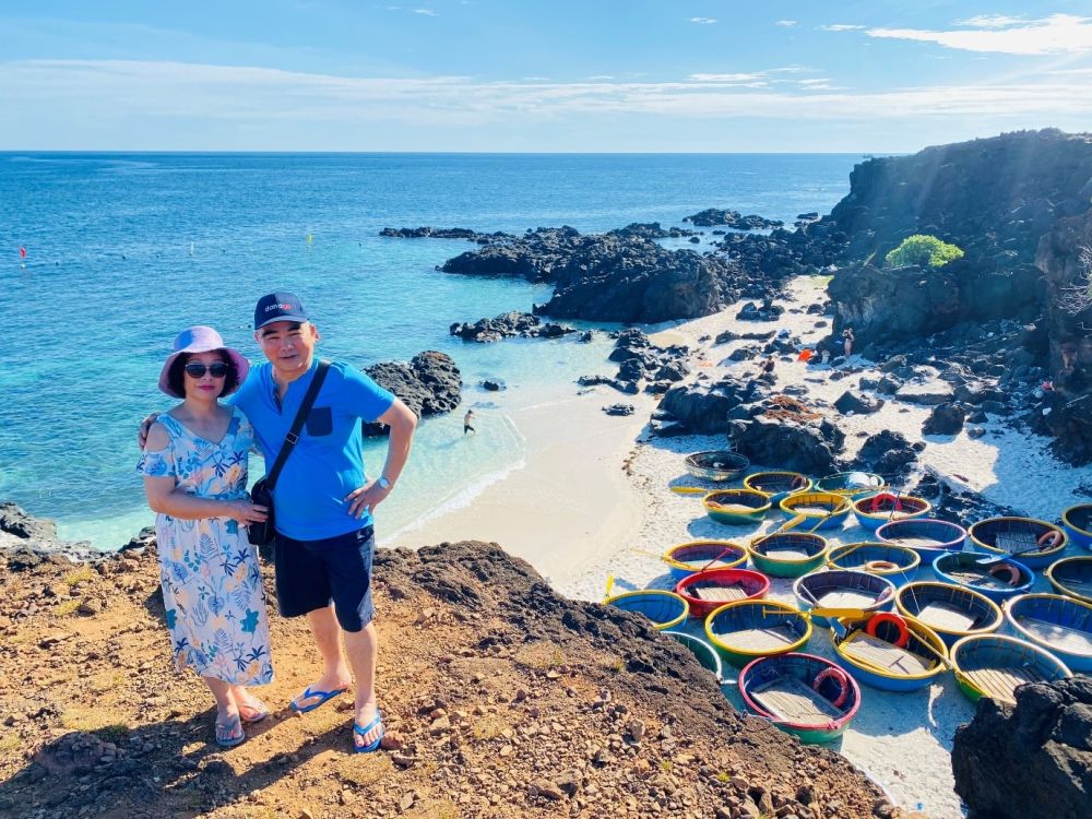 A person and person standing on a rocky beachDescription automatically generated